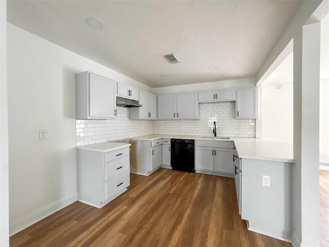 kitchen featuring dishwasher, dark wood-type flooring, sink, and decorative backsplash