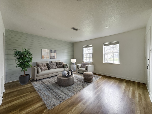 living room with wood-type flooring and a textured ceiling