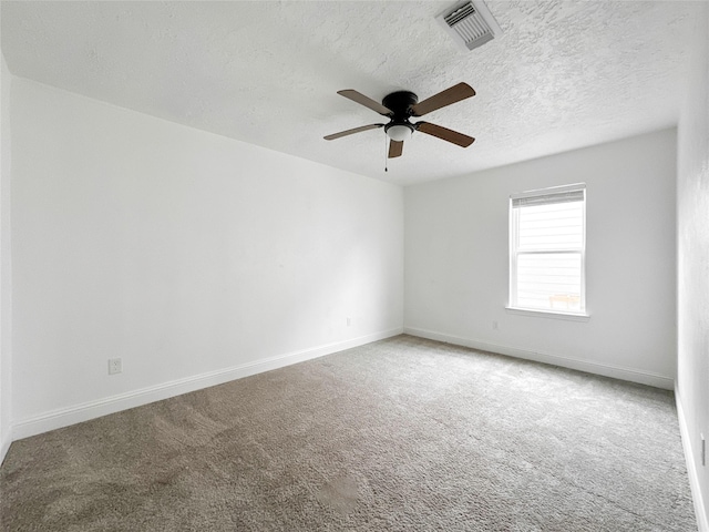 carpeted empty room featuring ceiling fan and a textured ceiling