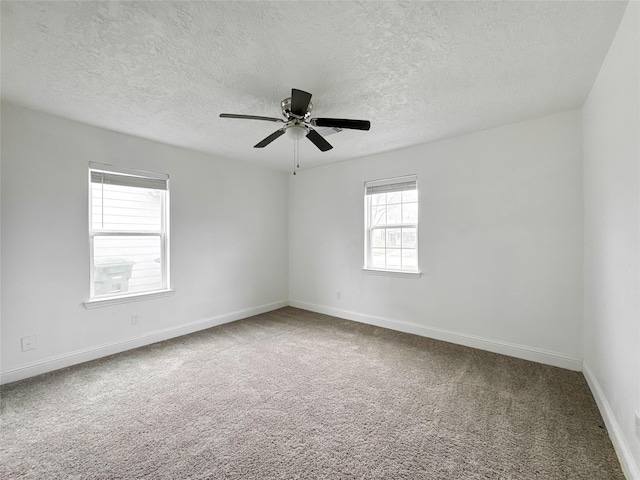 carpeted spare room featuring a textured ceiling and ceiling fan