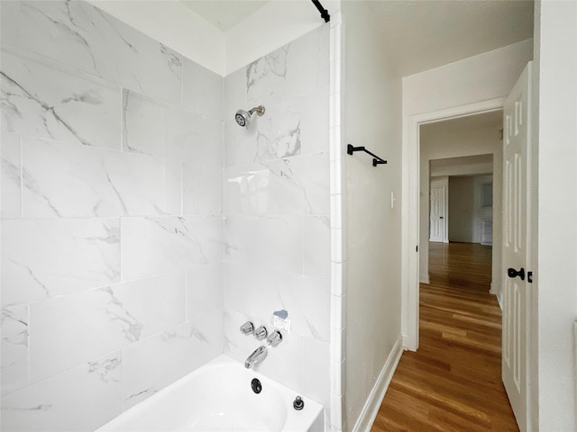 bathroom with tiled shower / bath and hardwood / wood-style floors