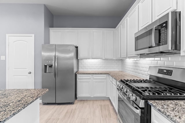 kitchen with white cabinets, stone countertops, and appliances with stainless steel finishes