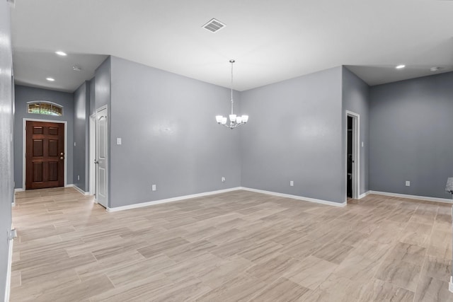 spare room featuring an inviting chandelier