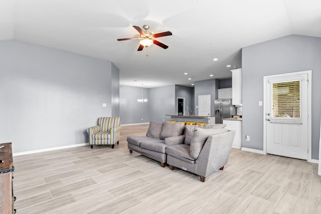 living room with ceiling fan with notable chandelier and lofted ceiling