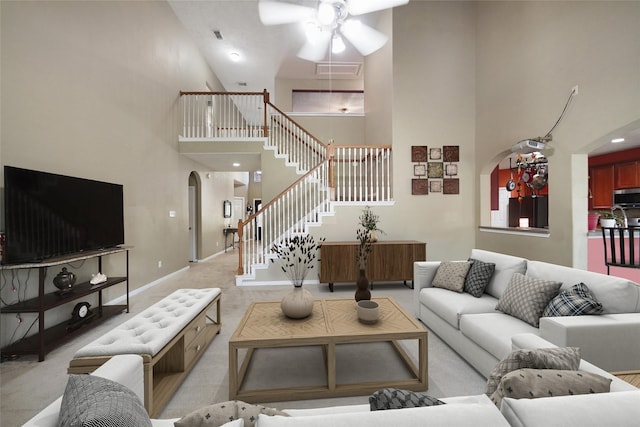 living room featuring ceiling fan and a towering ceiling