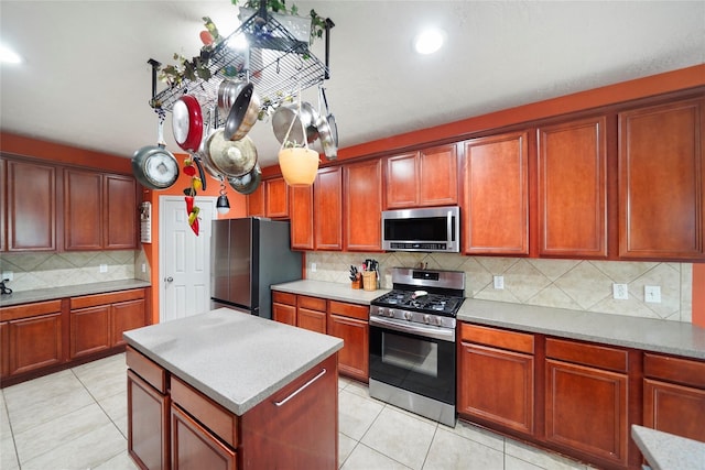 kitchen with decorative backsplash, light tile patterned floors, and stainless steel appliances