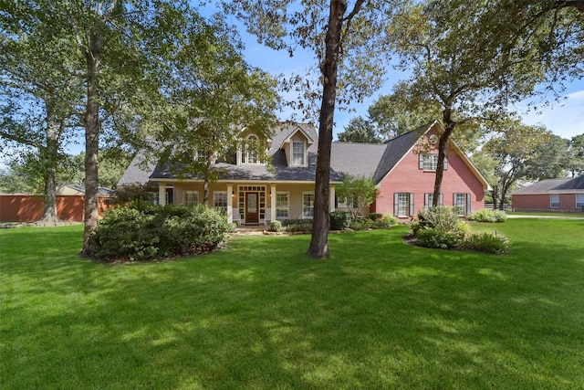 cape cod home featuring a front yard