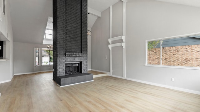 unfurnished living room with a fireplace, high vaulted ceiling, and light hardwood / wood-style flooring