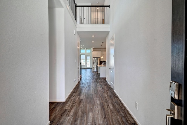 hallway with dark hardwood / wood-style flooring, a high ceiling, and french doors