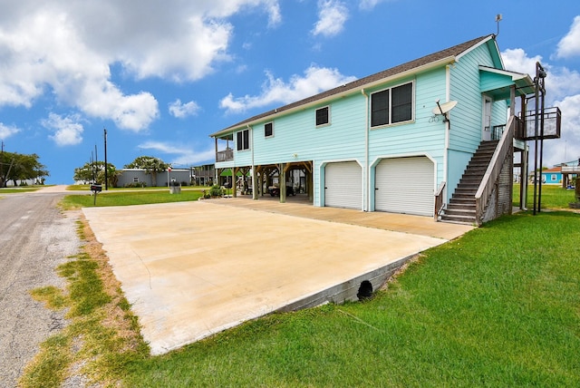 rear view of property with a yard, a garage, and a carport