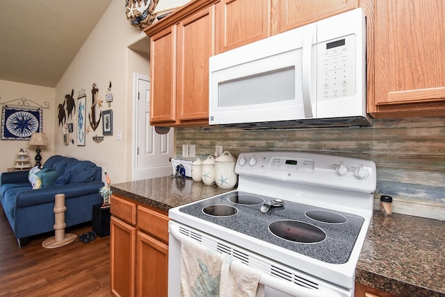 kitchen with wood walls, lofted ceiling, dark hardwood / wood-style floors, and white appliances