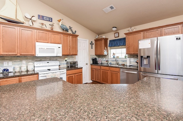 kitchen featuring appliances with stainless steel finishes, backsplash, lofted ceiling, and sink