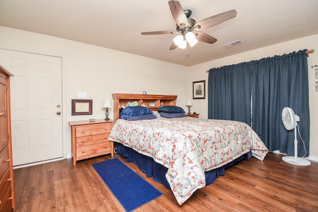 bedroom with dark hardwood / wood-style floors and ceiling fan