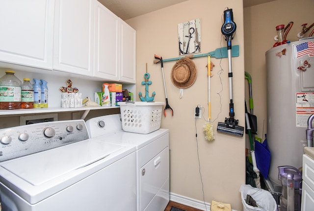 clothes washing area with washing machine and dryer, cabinets, and gas water heater