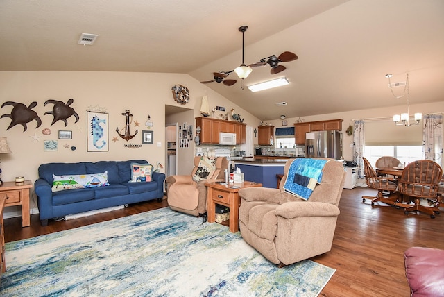 living room with ceiling fan with notable chandelier, wood-type flooring, and vaulted ceiling