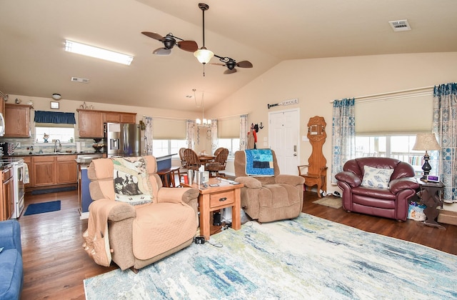 living room with ceiling fan with notable chandelier, dark hardwood / wood-style flooring, lofted ceiling, and sink