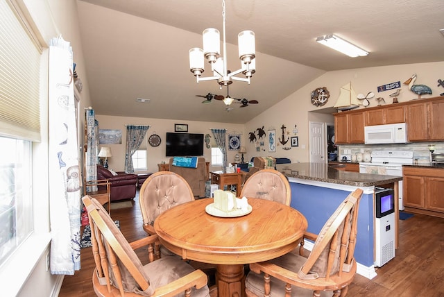 dining area with lofted ceiling, dark wood-type flooring, and a chandelier