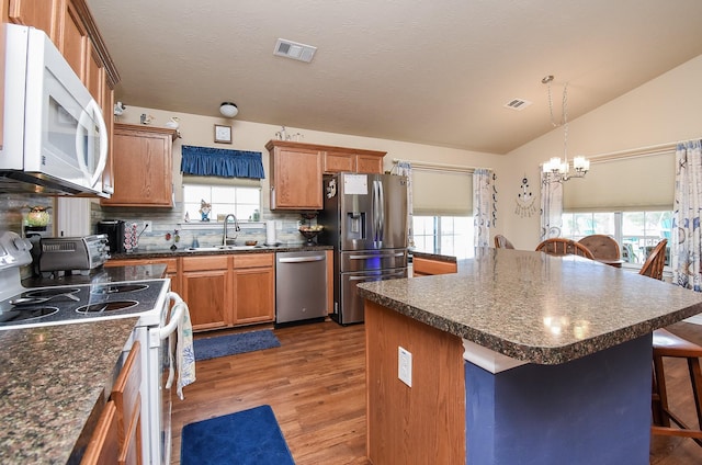 kitchen featuring a center island, sink, stainless steel appliances, a kitchen breakfast bar, and decorative backsplash