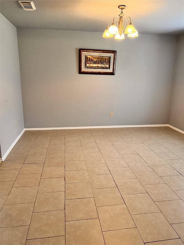 empty room featuring light tile patterned floors and an inviting chandelier