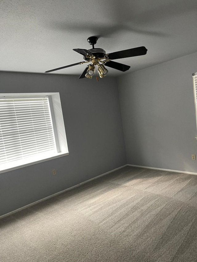 carpeted empty room featuring ceiling fan and a textured ceiling