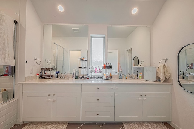 bathroom with tile patterned floors, vanity, and enclosed tub / shower combo