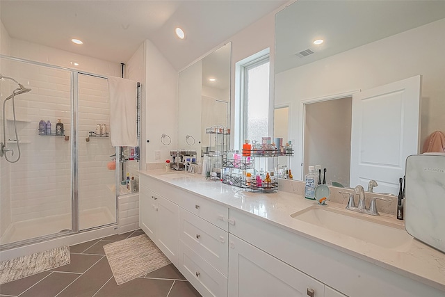 bathroom featuring tile patterned flooring, vanity, and a shower with shower door