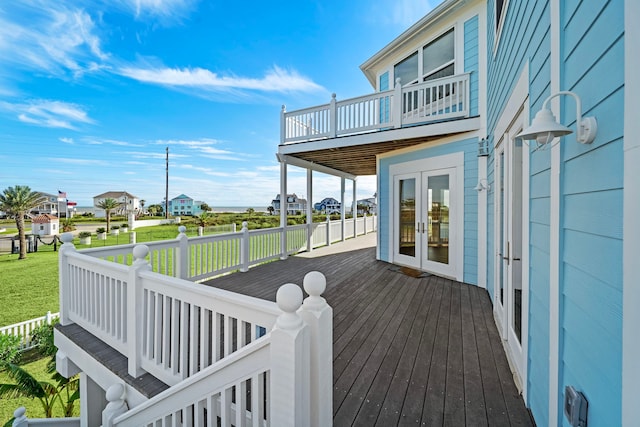 deck with french doors and a lawn