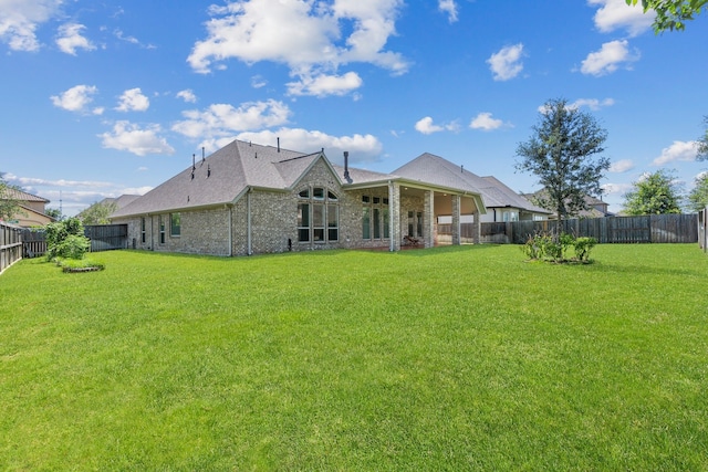 rear view of property featuring a yard