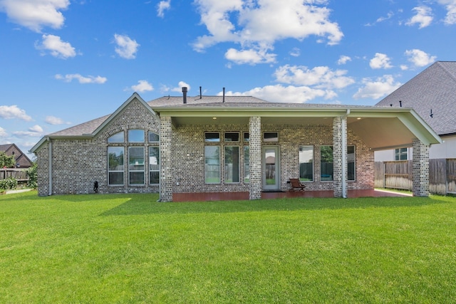 back of property featuring a lawn and a patio