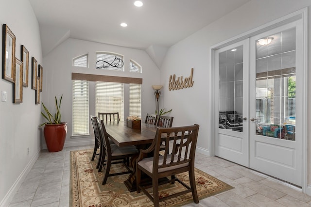 dining room with vaulted ceiling, light tile patterned floors, and french doors