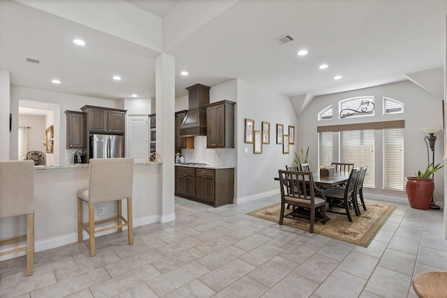 tiled dining room featuring vaulted ceiling