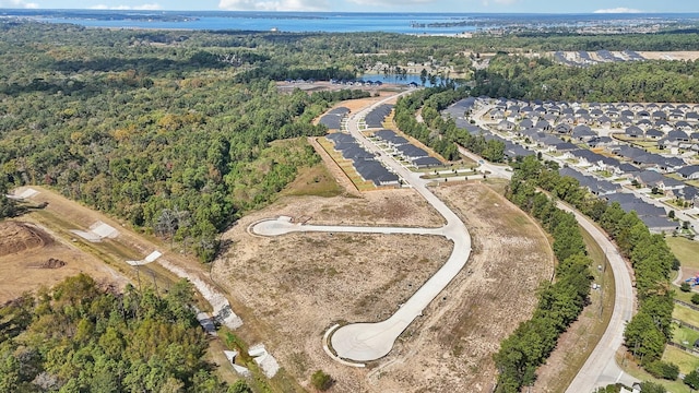 aerial view featuring a forest view and a water view