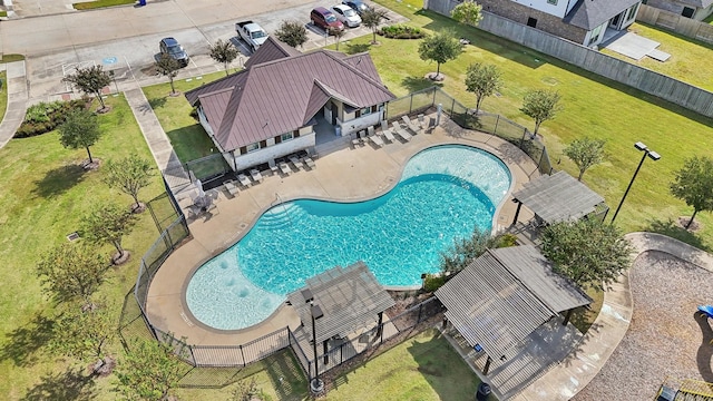 pool with a patio area and fence