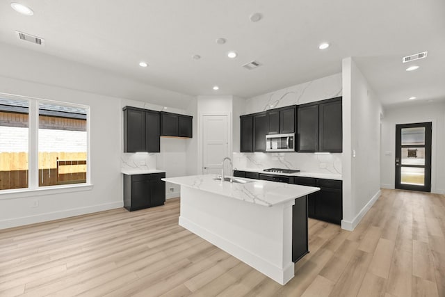 kitchen featuring dark cabinetry, visible vents, and appliances with stainless steel finishes