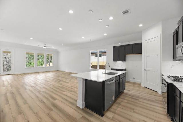 kitchen with visible vents, a sink, light countertops, appliances with stainless steel finishes, and dark cabinets