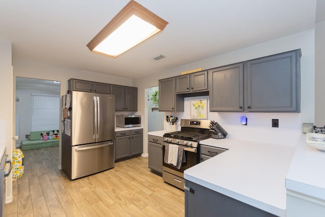 kitchen featuring gray cabinets, stainless steel appliances, and light hardwood / wood-style flooring