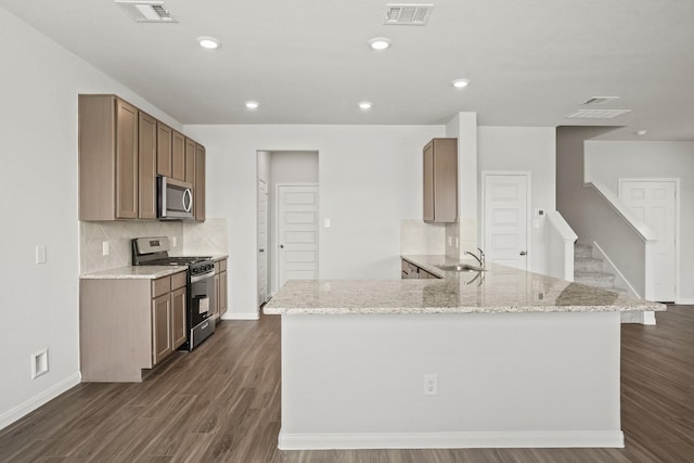 kitchen featuring sink, dark wood-type flooring, stainless steel appliances, and light stone counters