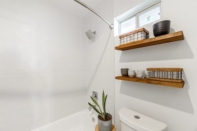 bathroom with tiled shower / bath combo and toilet