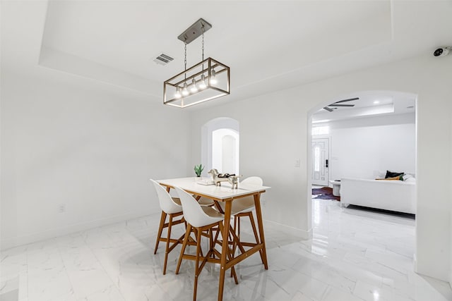 dining area featuring a raised ceiling