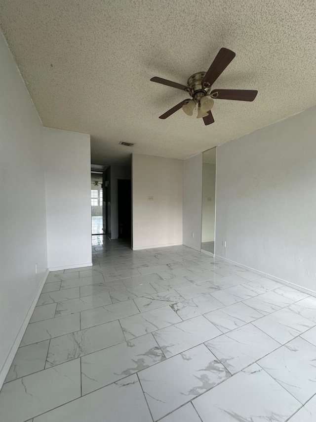 spare room with ceiling fan and a textured ceiling