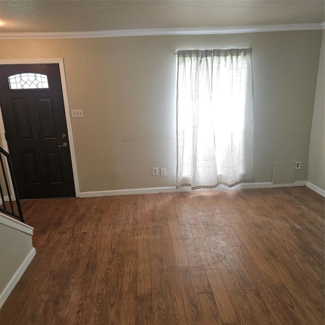 entrance foyer featuring crown molding and dark wood-type flooring