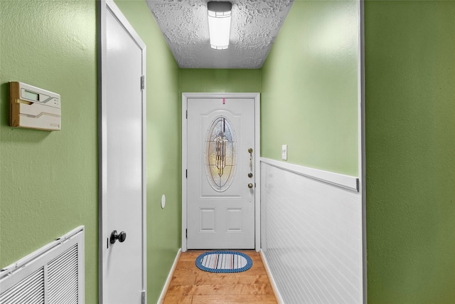 doorway to outside with hardwood / wood-style flooring and a textured ceiling