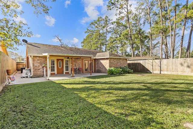 rear view of property featuring a patio, ceiling fan, and a lawn