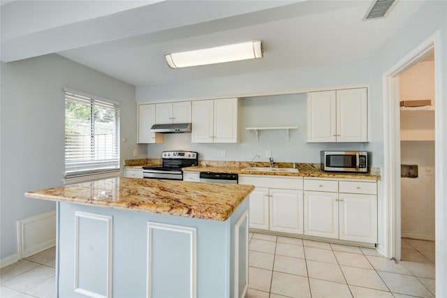 kitchen with stainless steel appliances, sink, white cabinets, a center island, and light tile patterned flooring