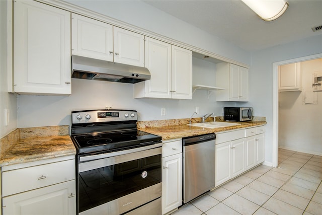 kitchen featuring light tile patterned flooring, appliances with stainless steel finishes, white cabinetry, and sink