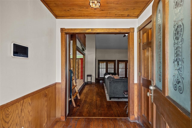 hallway with wood walls, dark wood-type flooring, and wood ceiling