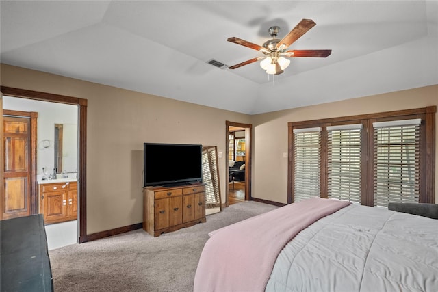 bedroom with light carpet, ensuite bathroom, a raised ceiling, vaulted ceiling, and ceiling fan