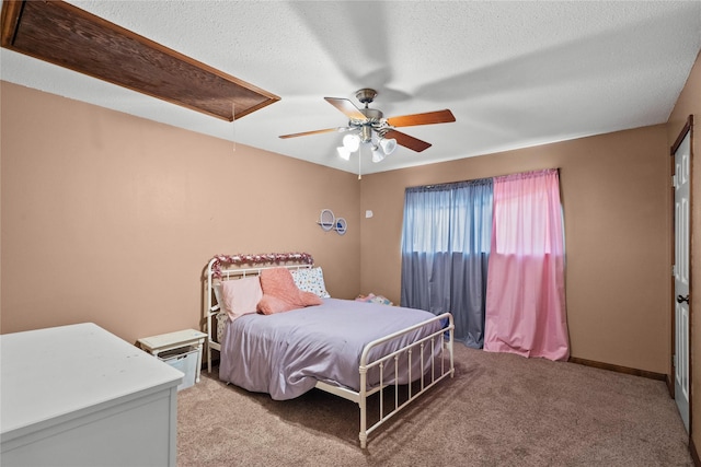 bedroom with ceiling fan, light colored carpet, and a textured ceiling