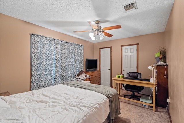 carpeted bedroom featuring ceiling fan and a textured ceiling