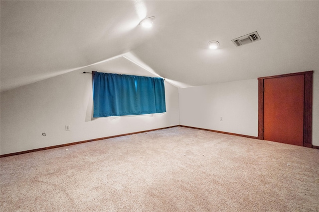 additional living space with carpet floors and vaulted ceiling